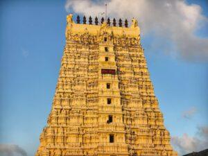 Magnificent view of Rameswaram temple gopuram with intricate carvings under clear blue sky.