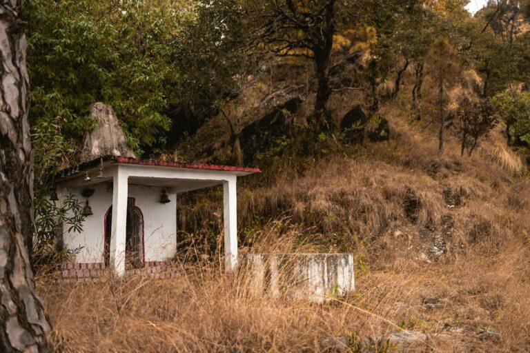 A small, rustic temple nestled in the serene landscape of Uttarakhand, India.