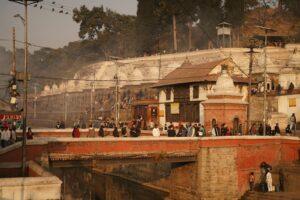 People gathering at Pashupatinath Temple in Kathmandu, Nepal, during evening light.