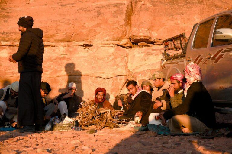 Group of men gathered around a campfire in desert.